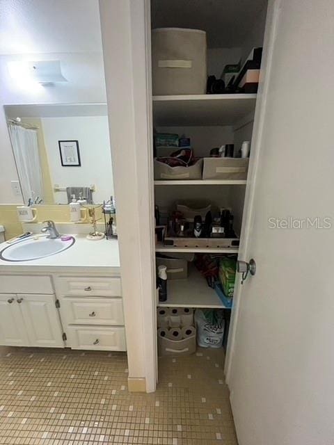 interior space with a closet, vanity, and tile patterned floors