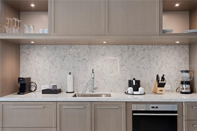 kitchen with tasteful backsplash, light brown cabinetry, and sink