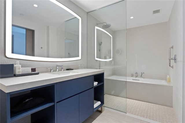 bathroom featuring vanity, independent shower and bath, and tile patterned flooring