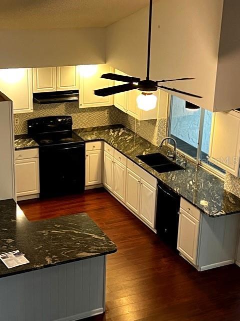 kitchen featuring sink, white cabinetry, backsplash, dark hardwood / wood-style floors, and black appliances