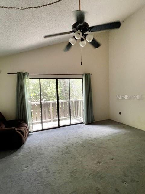 unfurnished living room featuring vaulted ceiling, carpet floors, ceiling fan, and a textured ceiling