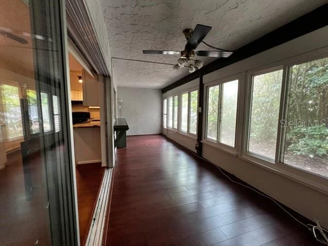 unfurnished sunroom featuring ceiling fan