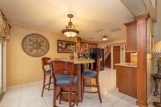 dining space featuring bar area and light tile floors