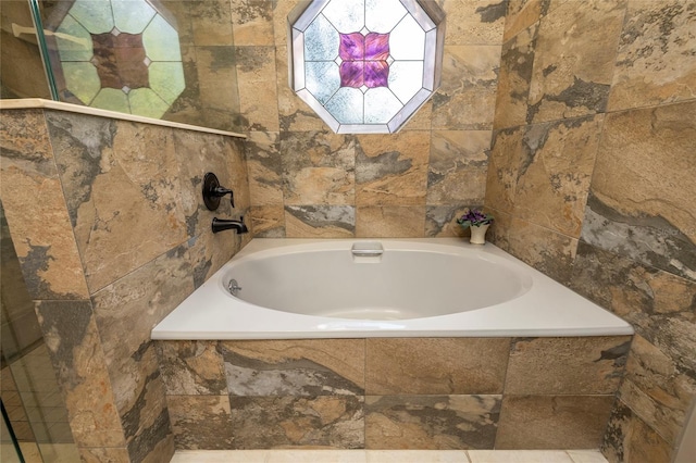 bathroom featuring a relaxing tiled bath