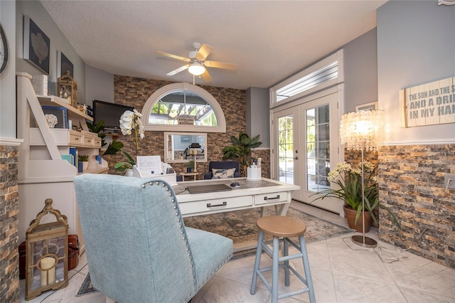 living room featuring ceiling fan, a textured ceiling, light tile floors, and a healthy amount of sunlight