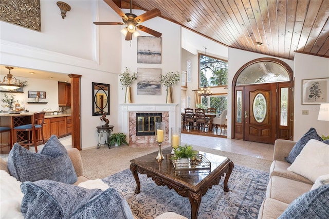 761 Soundview Dr, Palm Harbor, FL 34683 - living area featuring high vaulted ceiling, wood ceiling, ceiling fan, and a tile fireplace