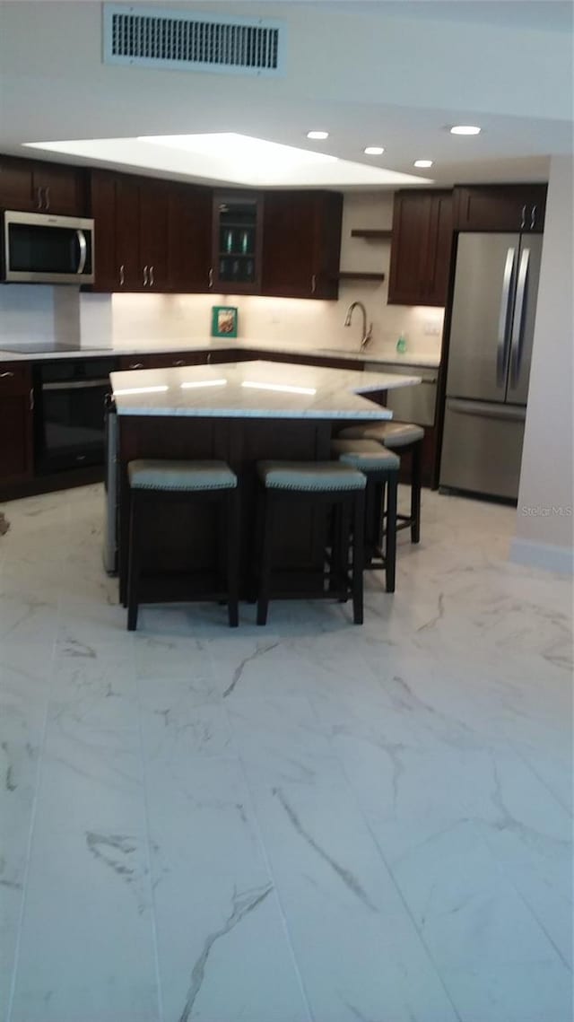 kitchen with a kitchen breakfast bar, stainless steel appliances, and sink