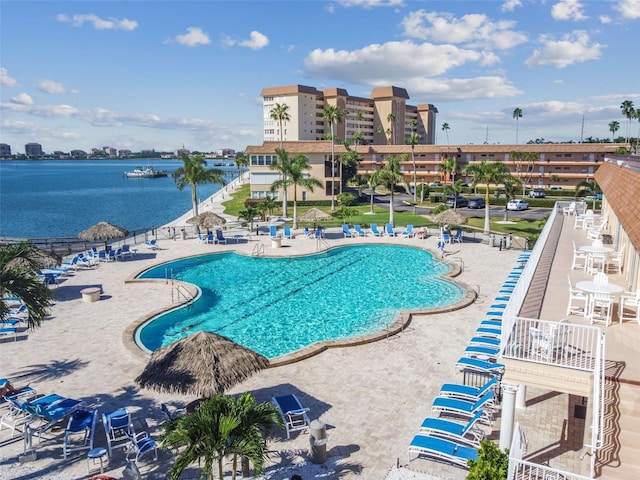 view of swimming pool with a patio and a water view