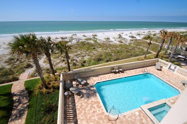 view of pool with a view of the beach and a water view