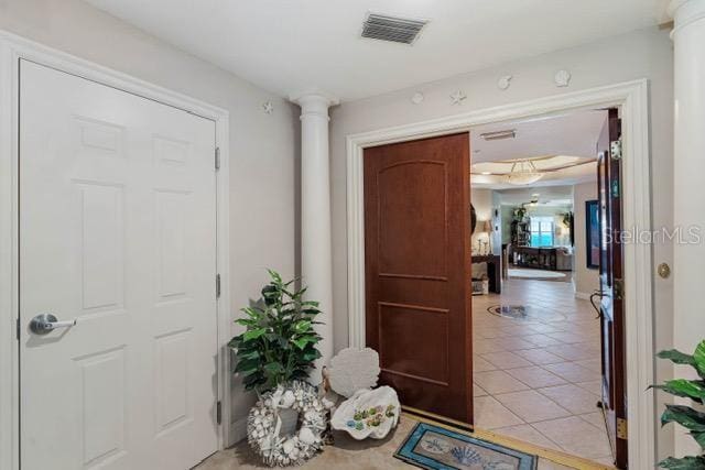 entrance foyer with ornate columns and light tile patterned floors