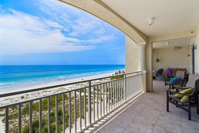 balcony featuring a view of the beach and a water view