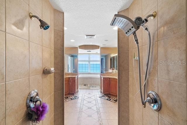 bathroom featuring vanity, tile patterned floors, a textured ceiling, and plus walk in shower