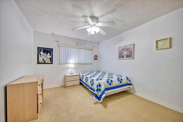 carpeted bedroom featuring ceiling fan and a textured ceiling