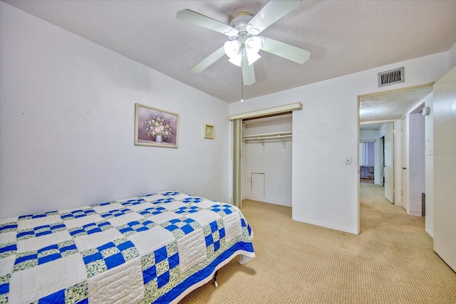 carpeted bedroom with ceiling fan and a closet