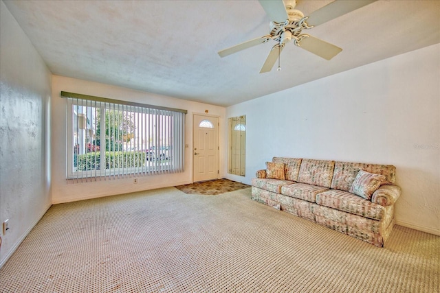 carpeted living room with ceiling fan