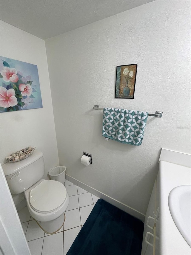 bathroom with toilet, tile patterned flooring, and vanity