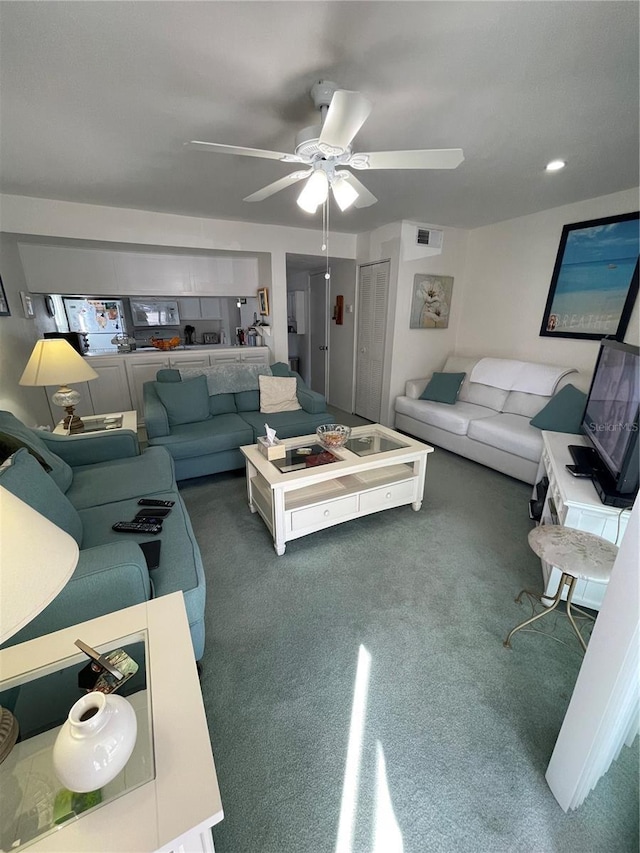 living room with ceiling fan and dark colored carpet