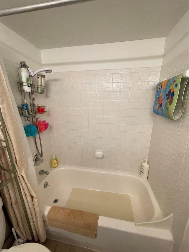 bathroom with toilet and shower / bath combination with curtain