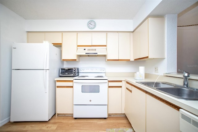 kitchen featuring a textured ceiling, light hardwood / wood-style floors, sink, cream cabinetry, and white appliances