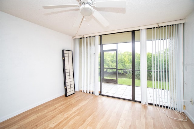 empty room featuring ceiling fan, a textured ceiling, and light wood-type flooring