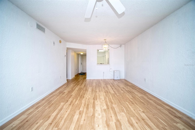 unfurnished living room featuring ceiling fan, a textured ceiling, and light hardwood / wood-style flooring