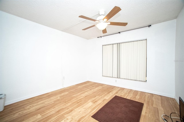 spare room featuring a textured ceiling, wood-type flooring, and ceiling fan