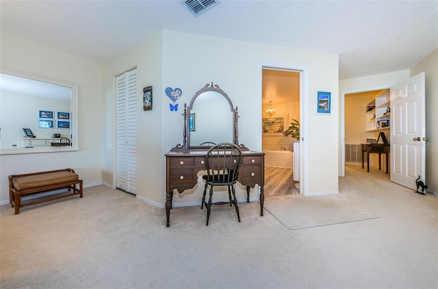 hall featuring carpet floors, visible vents, a textured ceiling, and baseboards