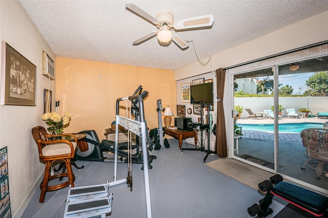 exercise room featuring ceiling fan and a textured ceiling