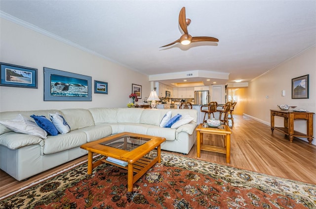 living room with ceiling fan, light hardwood / wood-style floors, and ornamental molding