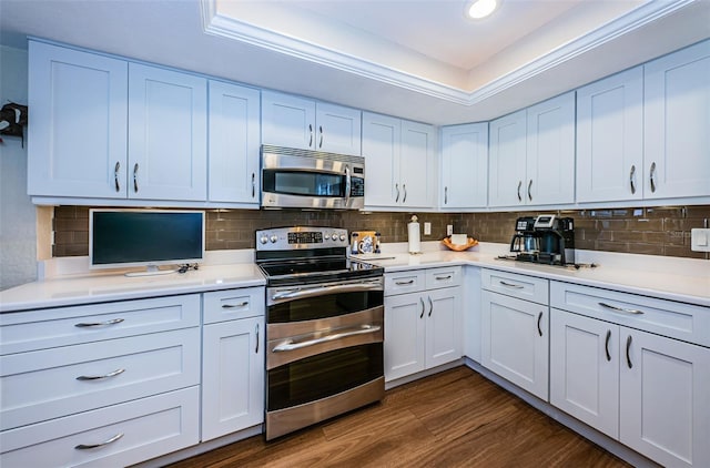 kitchen featuring decorative backsplash, appliances with stainless steel finishes, white cabinetry, and dark wood-type flooring