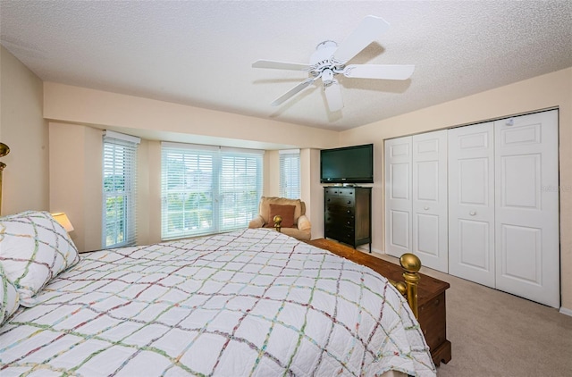 bedroom featuring carpet, ceiling fan, a textured ceiling, and a closet