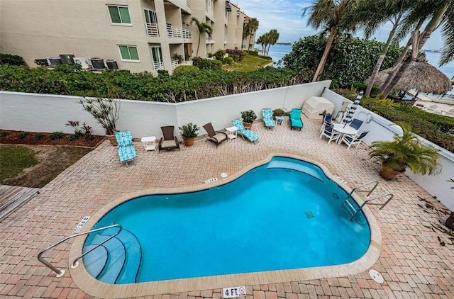 view of swimming pool with a patio and a water view