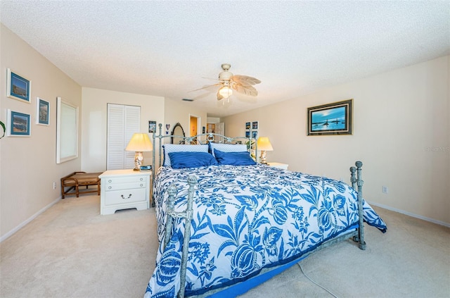 bedroom with a textured ceiling, ceiling fan, carpet flooring, and baseboards