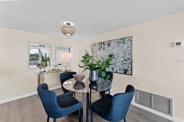 dining space with wood-type flooring