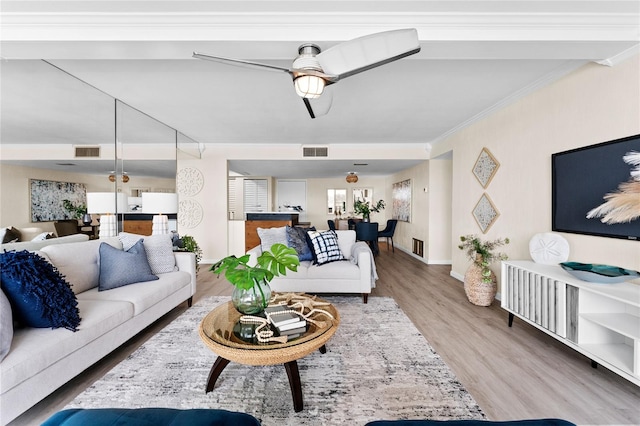 living room featuring ceiling fan, hardwood / wood-style floors, and ornamental molding