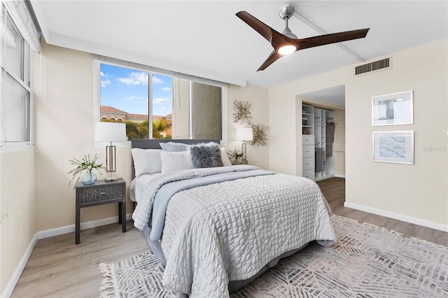 bedroom with a closet, light hardwood / wood-style flooring, and ceiling fan