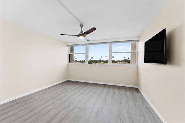 empty room featuring ceiling fan, light hardwood / wood-style flooring, and rail lighting