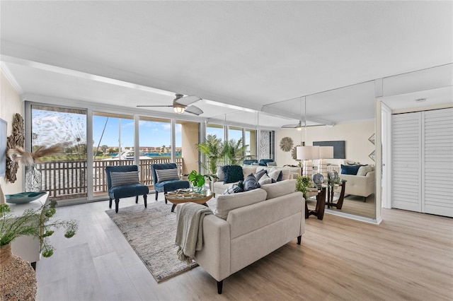 living room with light hardwood / wood-style flooring, floor to ceiling windows, and ceiling fan