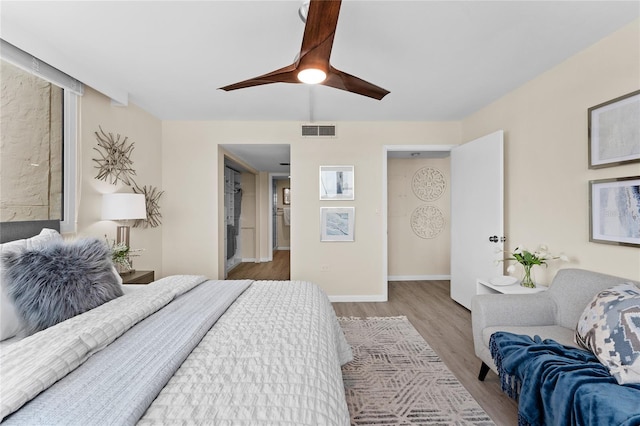 bedroom featuring ceiling fan, ensuite bathroom, and light hardwood / wood-style floors