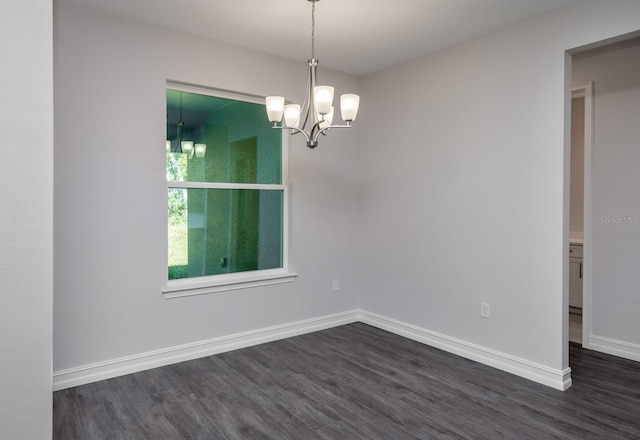 unfurnished dining area with dark hardwood / wood-style flooring and an inviting chandelier