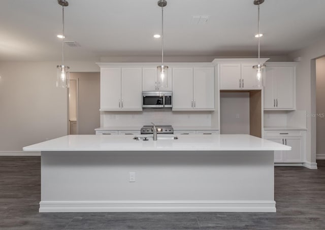 kitchen with white cabinets, sink, an island with sink, tasteful backsplash, and decorative light fixtures