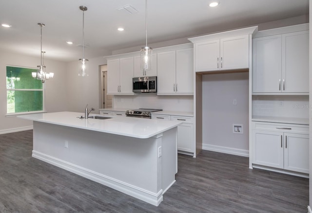 kitchen featuring appliances with stainless steel finishes, white cabinetry, and an island with sink