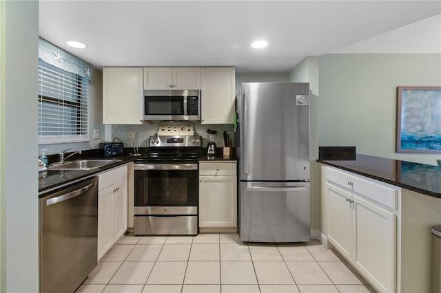 kitchen featuring white cabinets, sink, stainless steel appliances, and light tile patterned floors