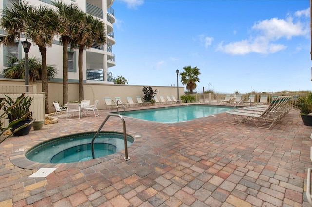 view of pool featuring a community hot tub and a patio area