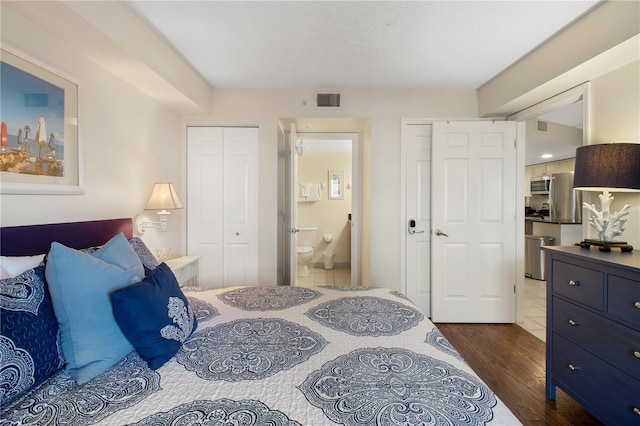 bedroom featuring wood-type flooring and ensuite bath