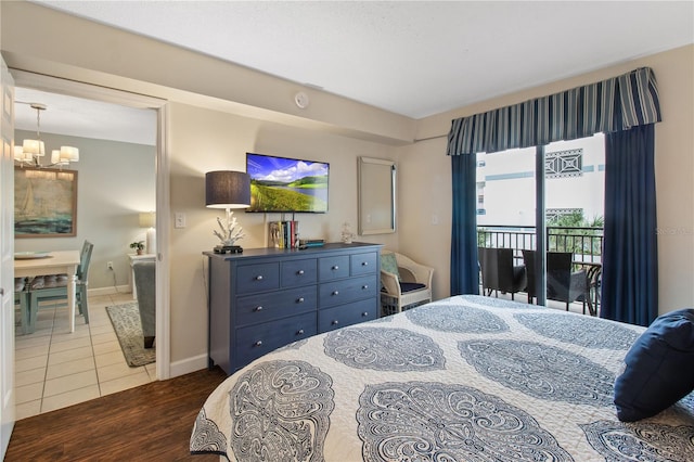 bedroom featuring access to exterior, hardwood / wood-style flooring, and a chandelier