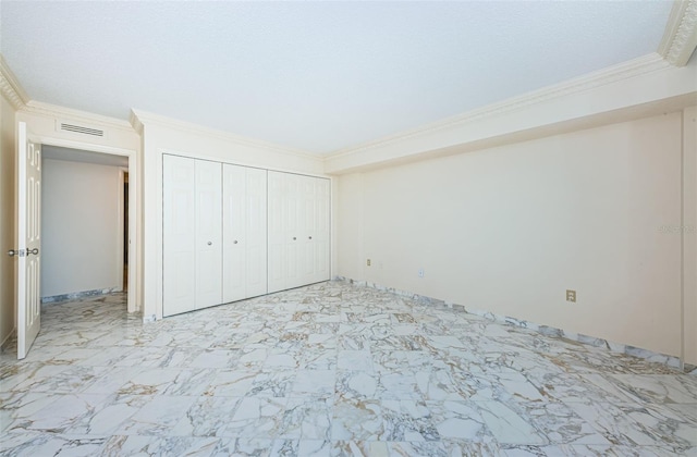 unfurnished bedroom with ornamental molding and a closet