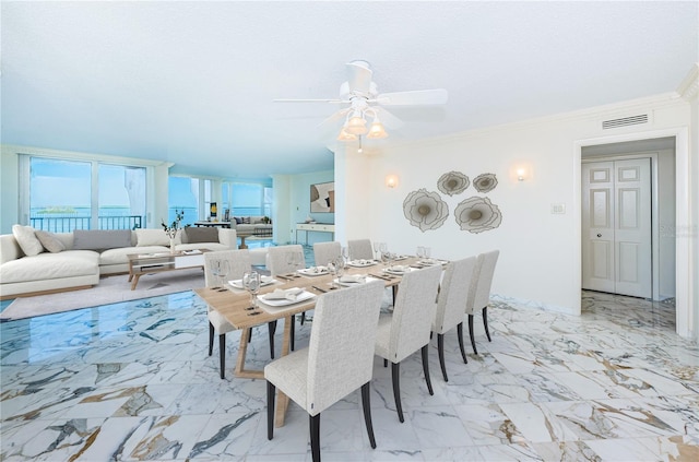 dining area featuring a water view, ceiling fan, and ornamental molding