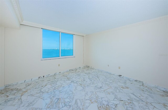 unfurnished room with crown molding and a textured ceiling