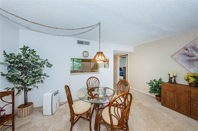 dining room with light carpet and a textured ceiling